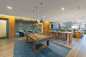 a pool table in a living room with tables and chairs